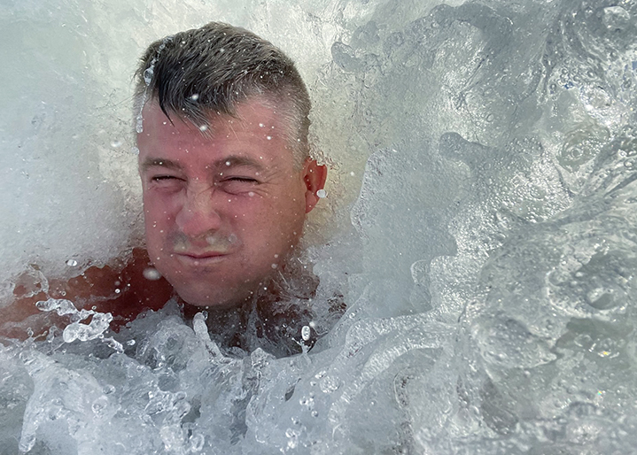 Me, eyes closed, being overtaken by an ocean wave