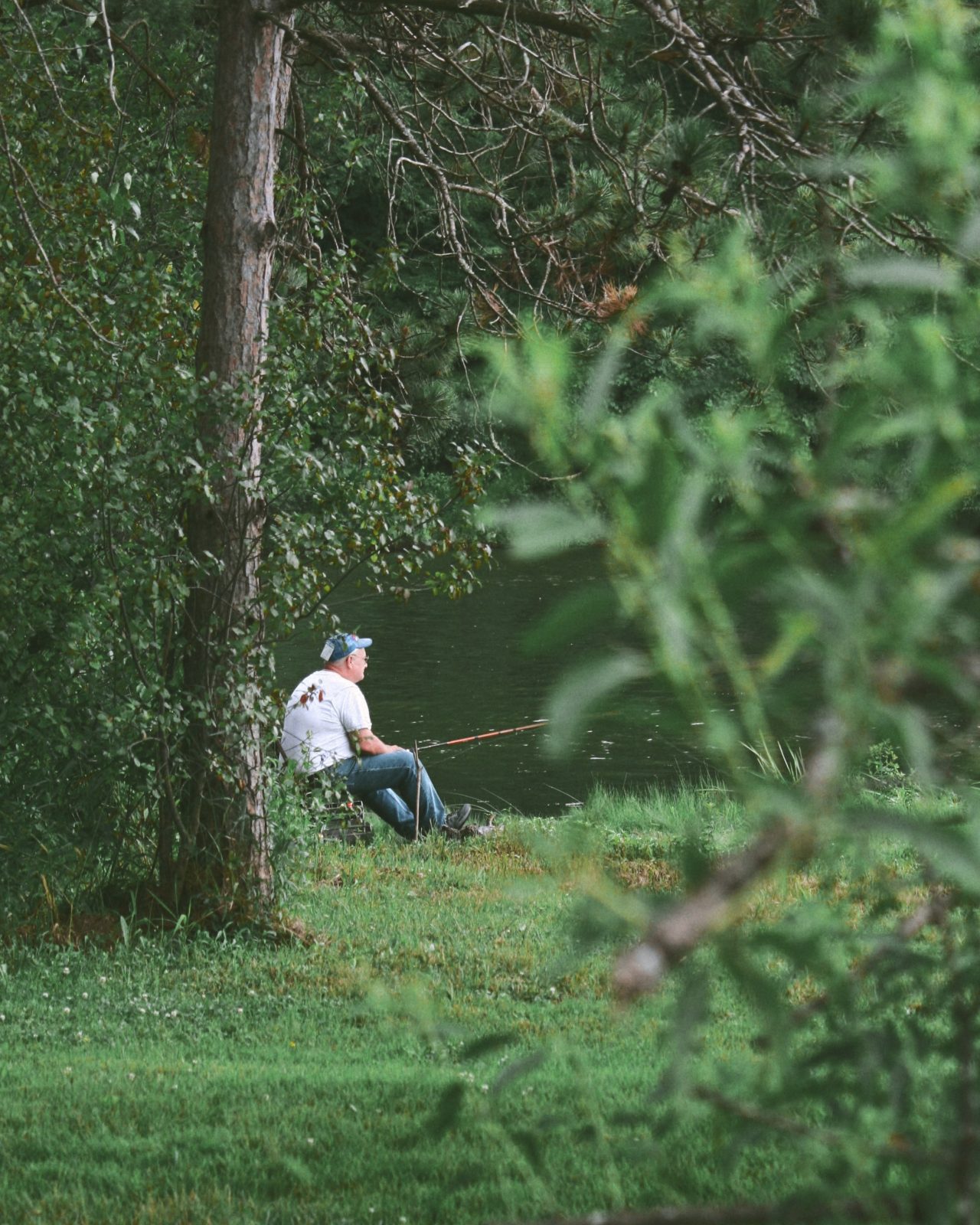 a man, fishing next to a lake